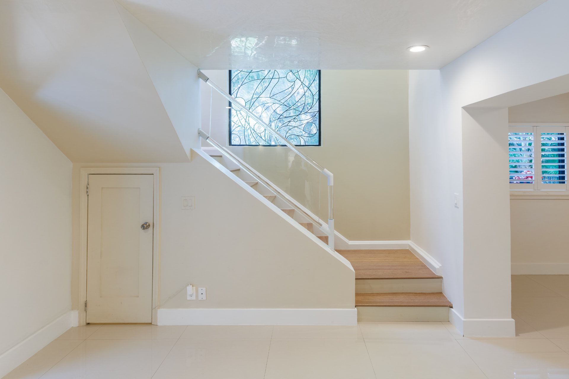 Staircase with leaded-glass accent window and wood treads