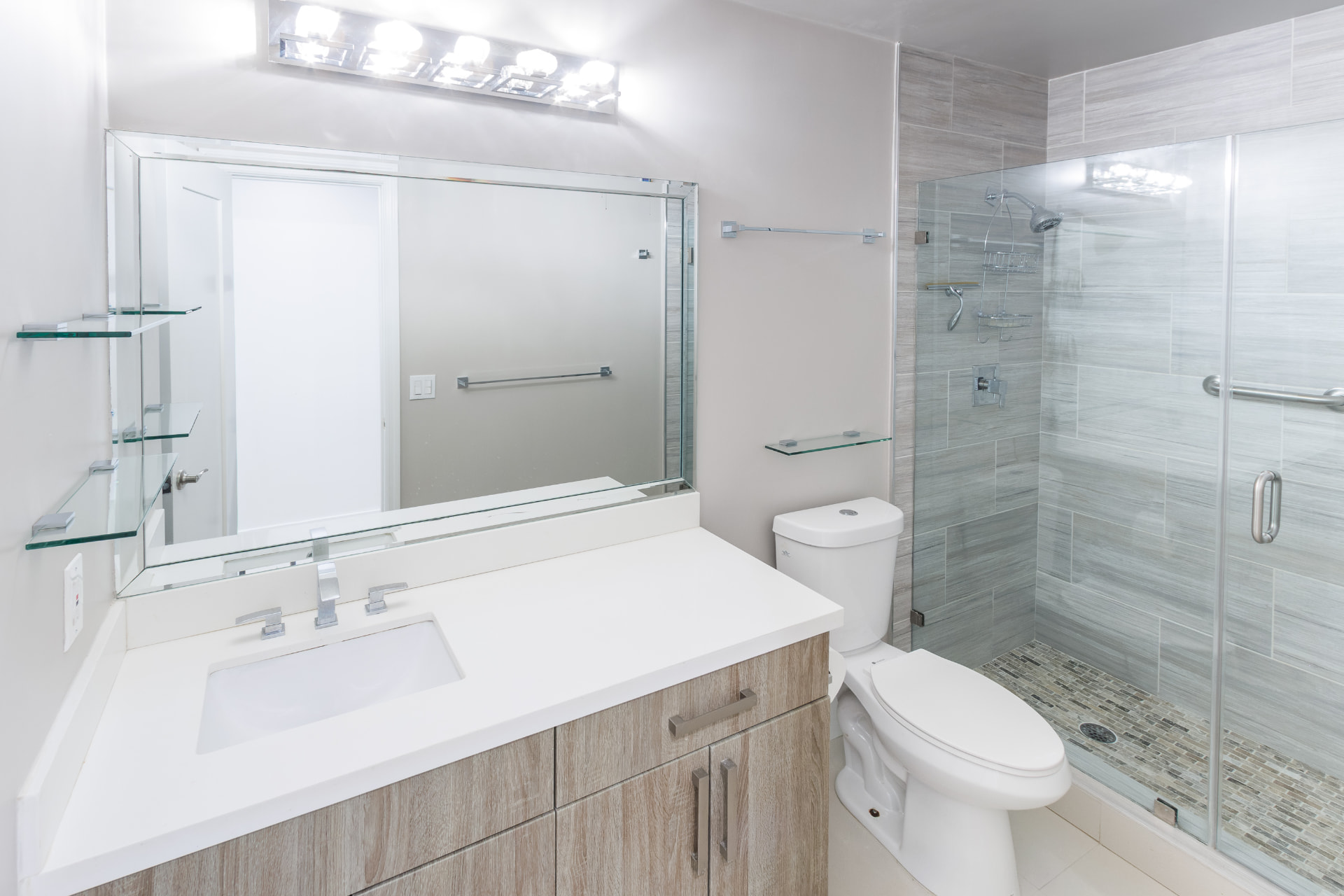 Guest bath with floating vanity and glass-enclosed shower