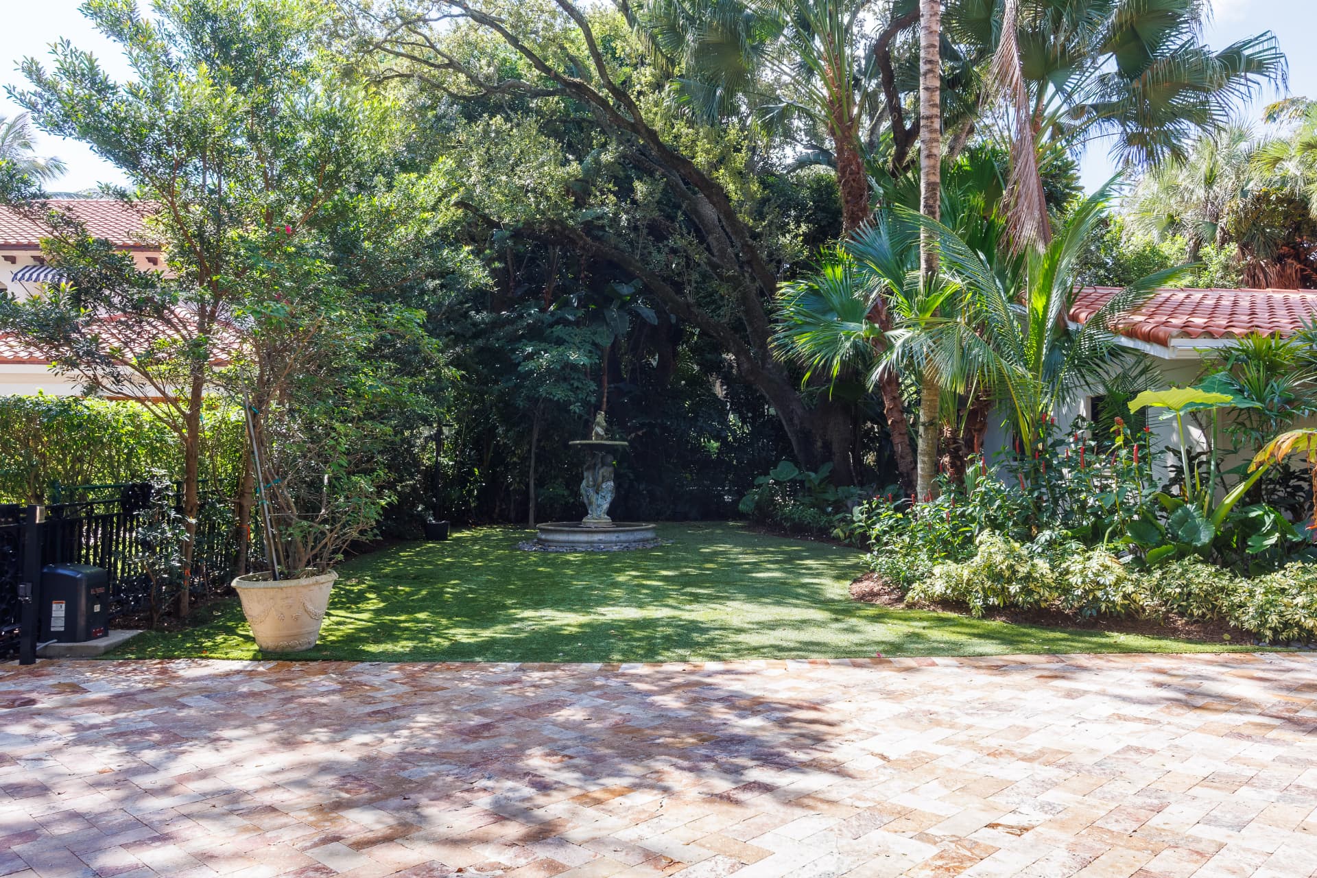 Paver courtyard opening to the lawn and fountain