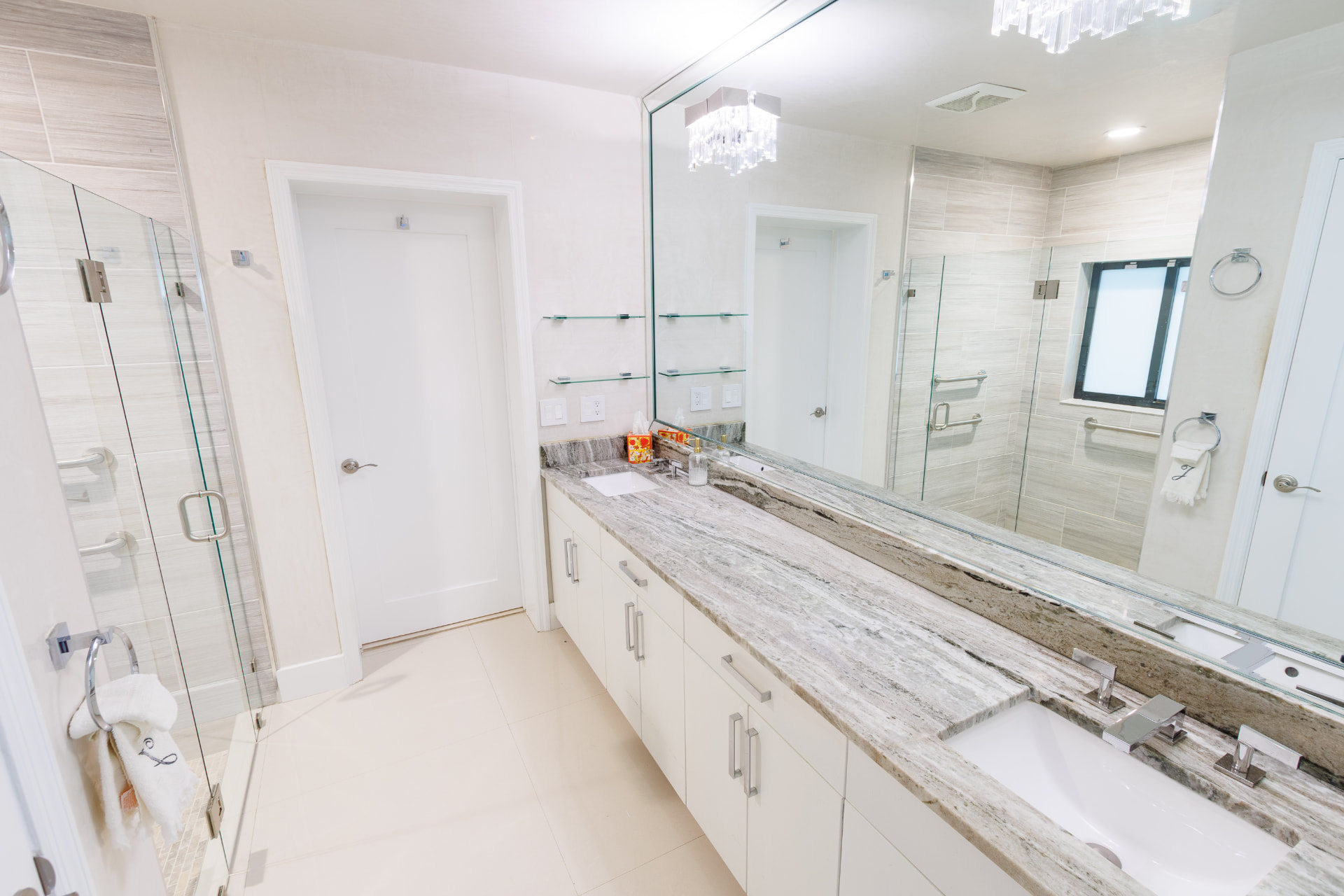 Primary bath with double vanity, granite counter and frameless glass shower