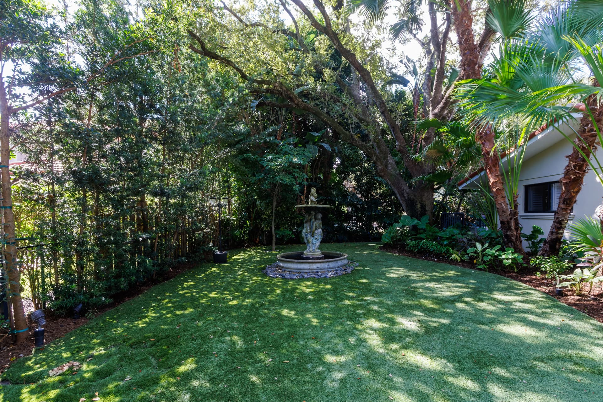 Turf lawn with a classical tiered stone fountain
