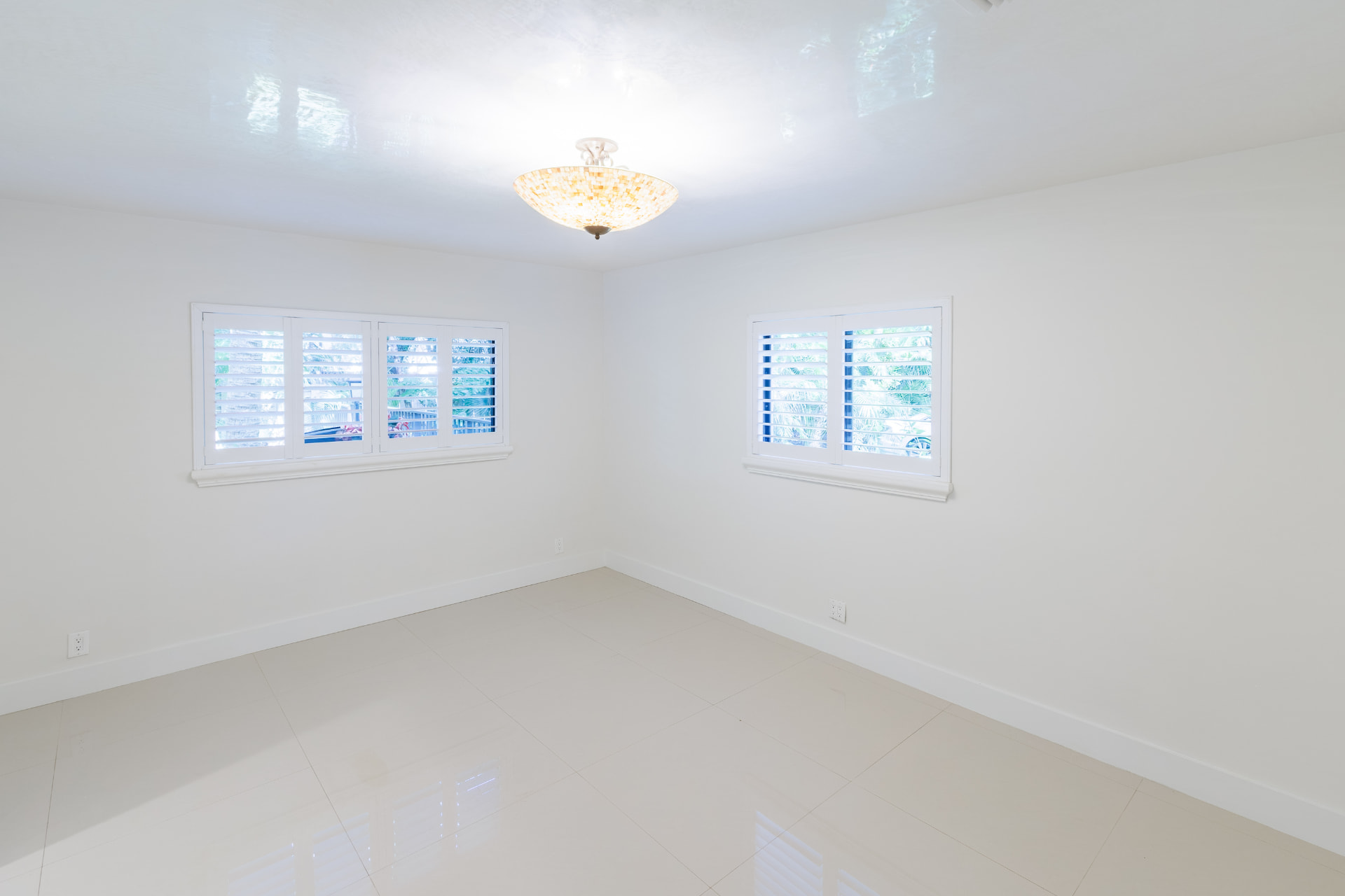 Bedroom with twin shuttered windows and a mosaic-glass chandelier