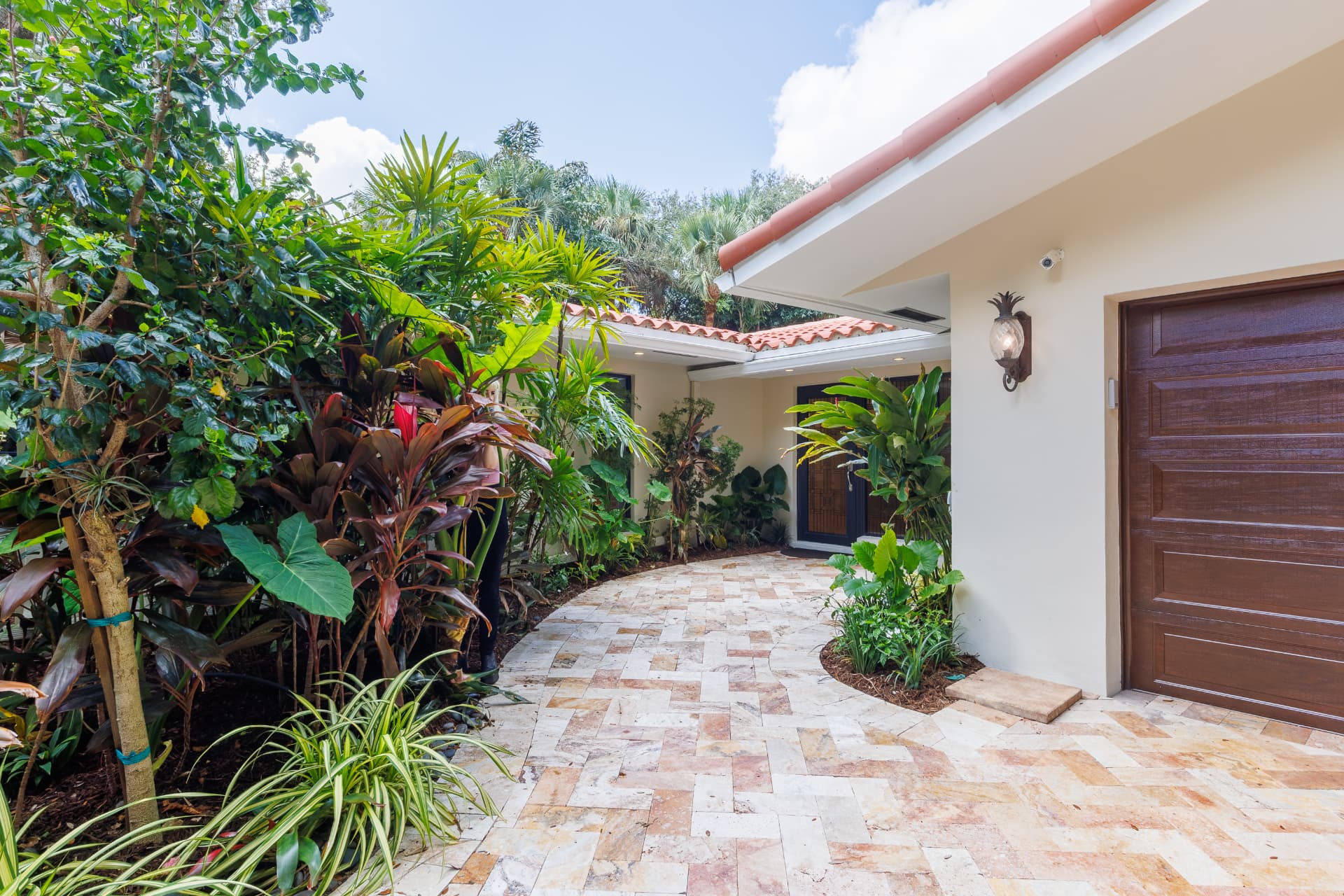 Paver walkway and tropical planting along the side entry