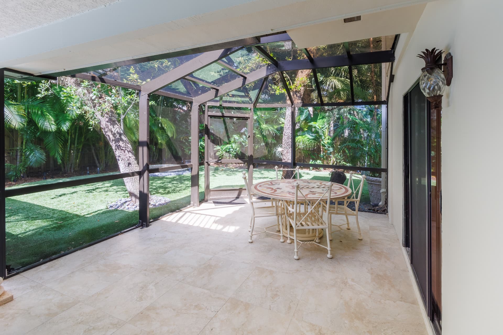Screened garden patio with seating beneath mature trees