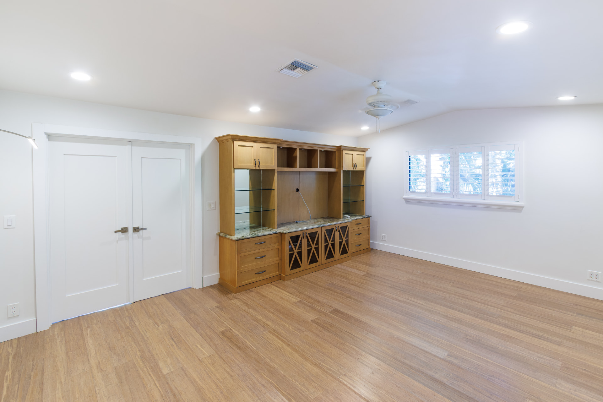 Bedroom with built-in entertainment wall and double doors