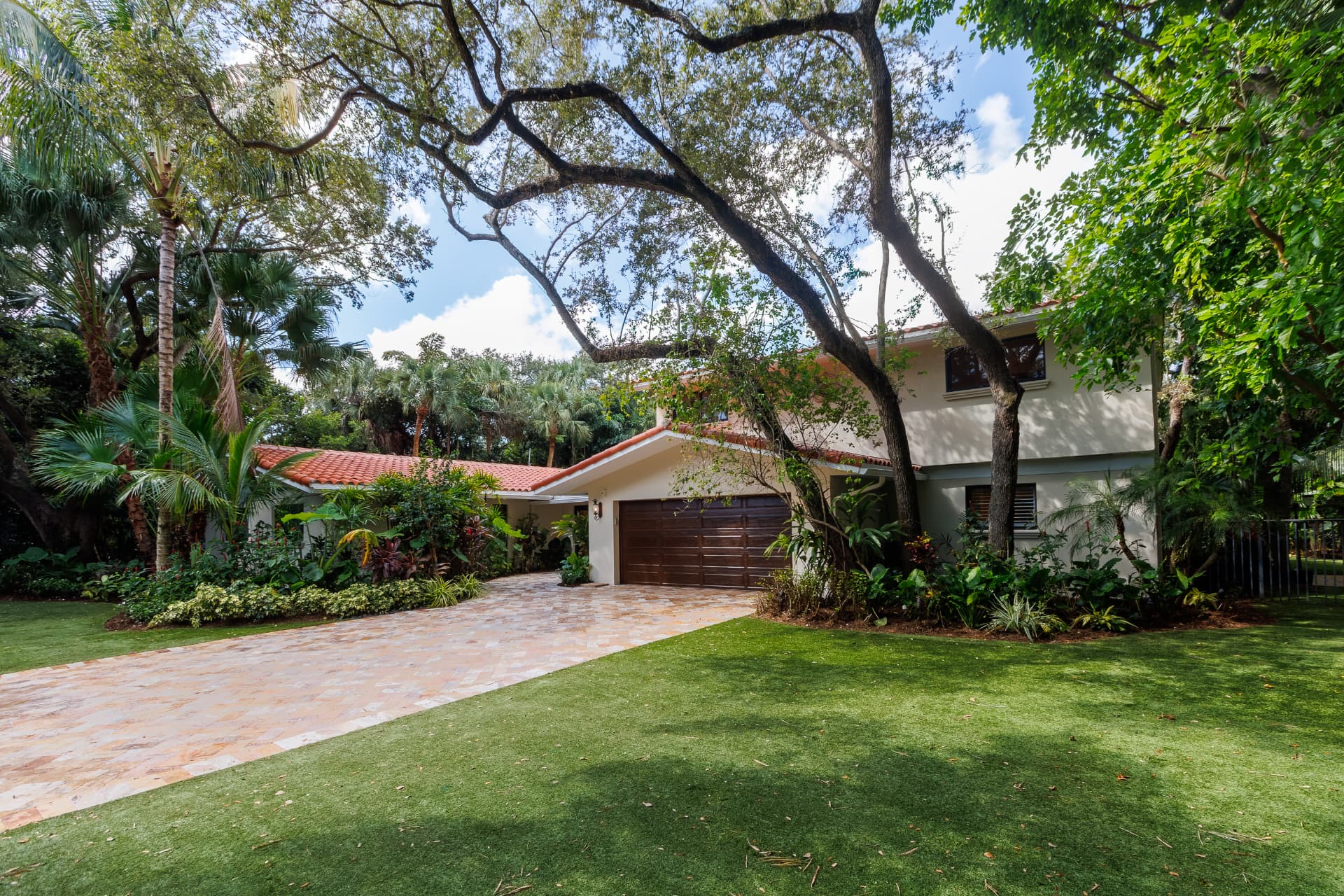 Mediterranean façade with terracotta tile roof and paver driveway