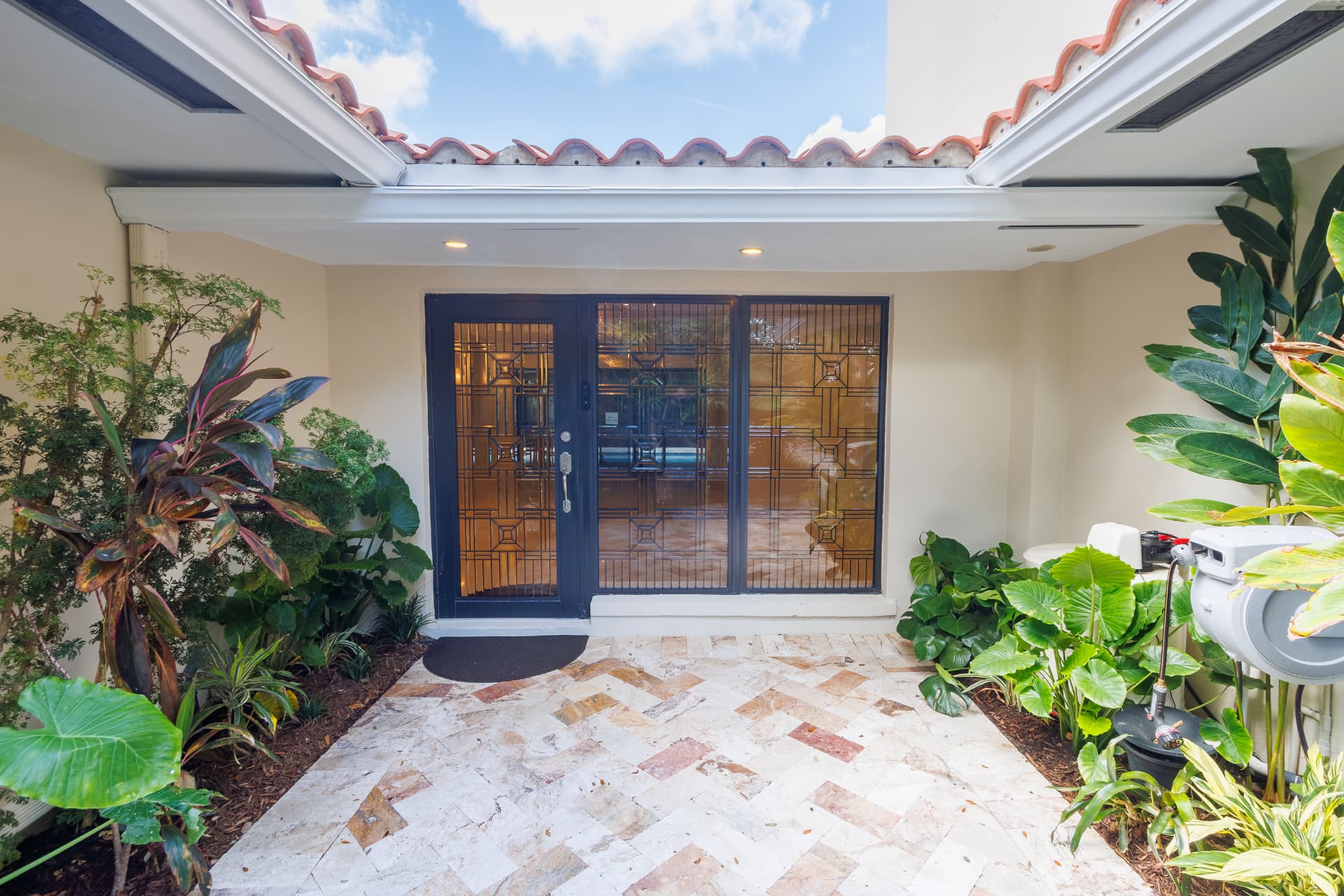 Covered entrance with leaded-glass doors and tile floor