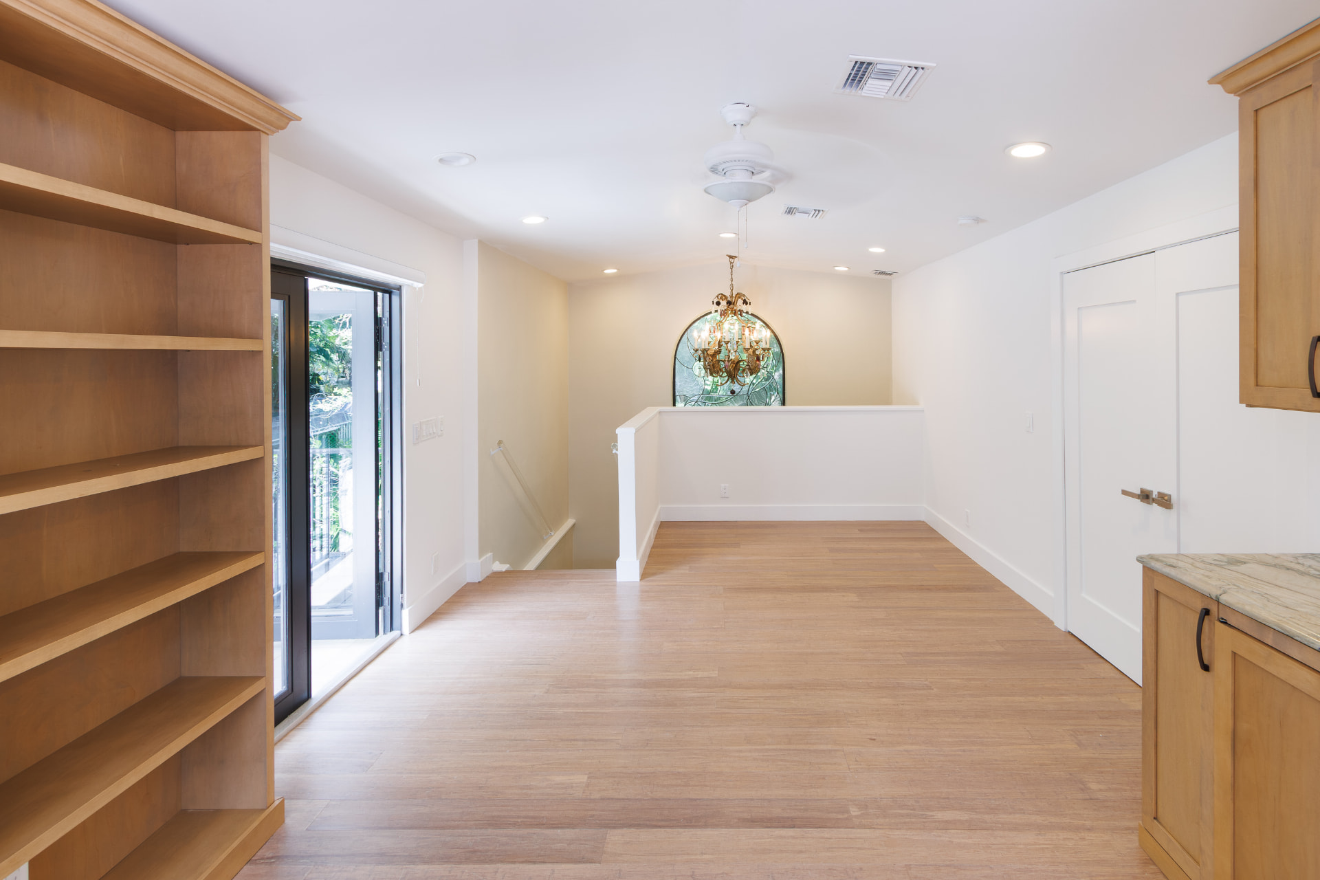 Upstairs landing with built-in shelving and a balcony door
