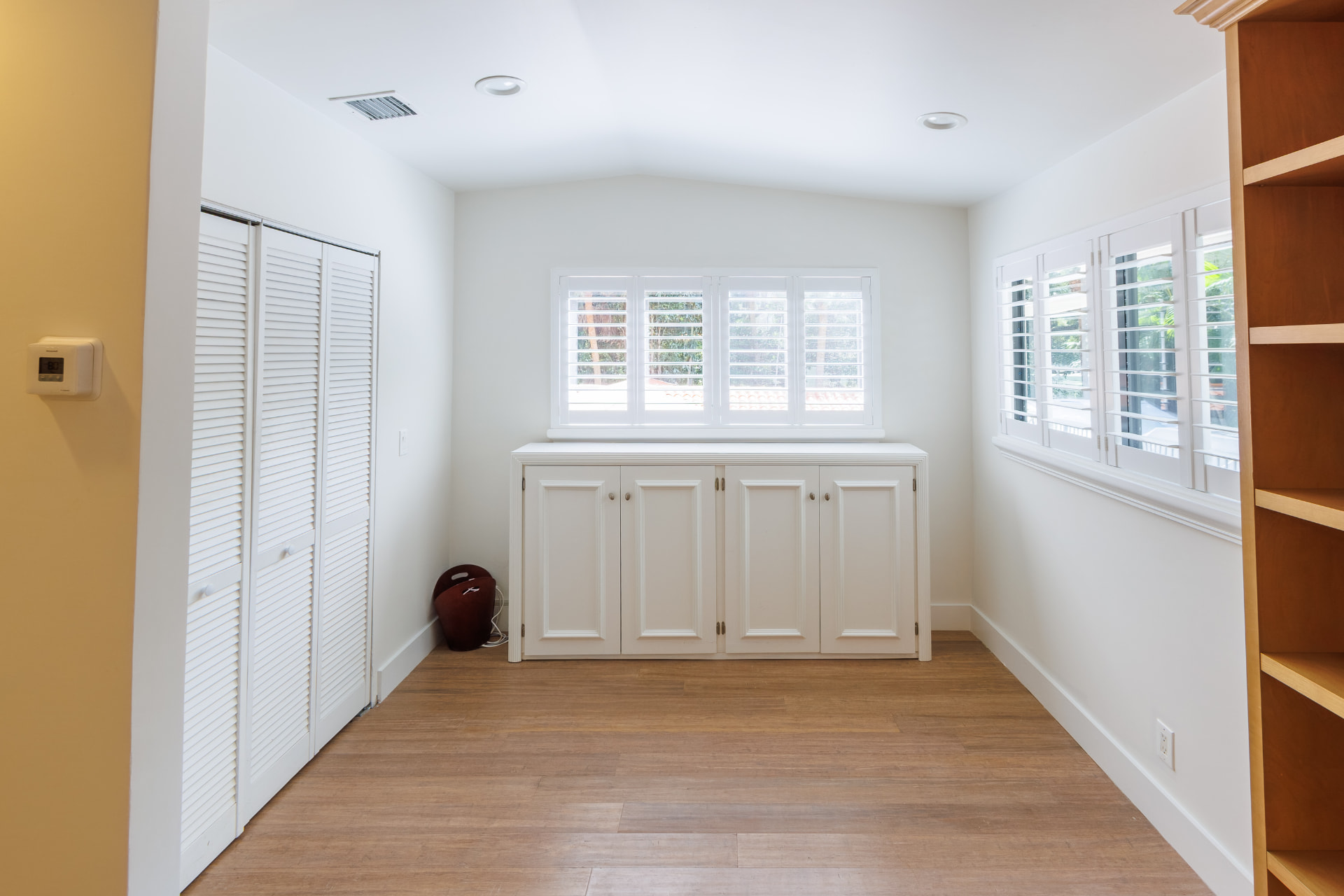 Sitting room with built-in cabinetry and plantation shutters